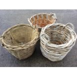 A cane log basket with wood handles; and another two circular cane/stick log baskets. (3)