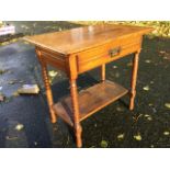 An Edwardian oak side table with rectangular top above a moulded frieze drawer, raised on ring-