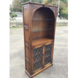 A Webber carved oak display cabinet with floral spandrels above glass shelves , the base with leaded