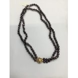 Cultured pearl necklace with two strings of purple/black freshwater cultured pearls on a 14ct gold