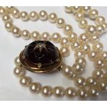 Cultured pearl two strand necklace with a Victorian carved garnet and old cut diamond cluster