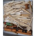 A collection of antique sewing items, carved bone needles cases including umbrellas, hooks and