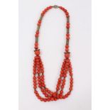 Old Chinese coral necklace with spherical polished beads and metal spacers, terminating with three