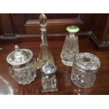 Silver collared glass perfume bottle, enamel topped silver glass perfume bottle and three others