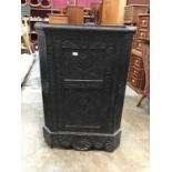 Antique heavily carved oak corner cupboard with shelved interior enclosed by carved panelled door