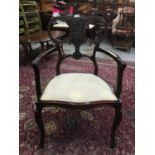 Edwardian mahogany elbow chair with carved floral decoration on cabriole legs