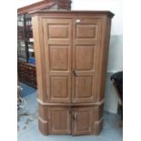 Antique pine corner cupboard with shaped shelves and painted interior enclosed by panelled doors