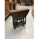 Oak oval drop leaf table on spiral twist legs joined by stretchers