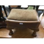 A rectangular footstool with upholstered top, on carved claw and ball feet