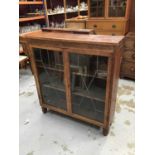 Carved oak bookcase enclosed by two astragal leaded glazed doors