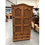 Modern pine kitchen cupboard with fitted interior with wine rack enclosed by lattice doors