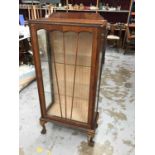 Walnut display cabinet with glass shelves enclosed by glazed door