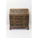 Arts and Crafts carved oak bureau, finely carved with dragons and scrolling acanthus ornament, fitte