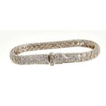 Diamond bracelet with an articulated tapered band of pavé set brilliant cut diamonds, the stylised b