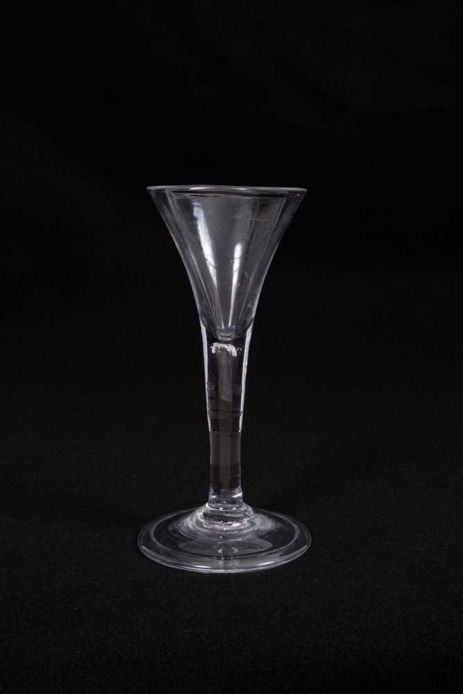 Georgian wine glass, the trumpet bowl on a plain stem with teardrop inclusion, above a conical foot,