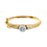 Antique sapphire and diamond hinged bangle, the central flower head cluster with a cushion cut cornf