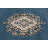 Aubusson style rug, with central oval foliate medallion on pale blue ground, 345 x 250cm