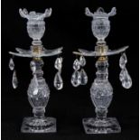 Pair of Regency period cut glass lustre candlesticks, the drip pans hanging with faceted drop shapes