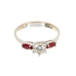 Diamond and ruby three stone ring with a central brilliant cut diamond estimated to weigh approximat