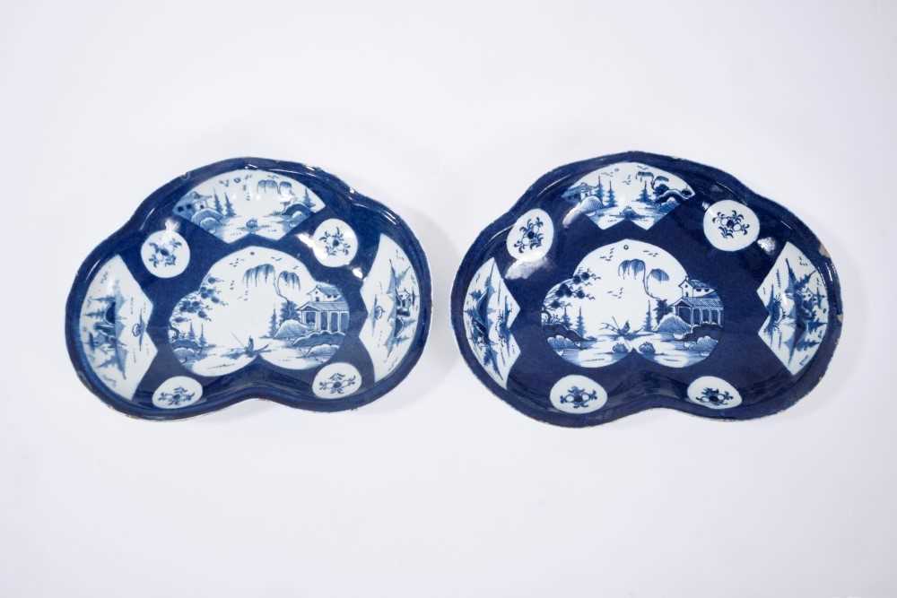 Pair of Bow blue and white kidney-shaped dishes, circa 1760, the central panel painted with a fisher