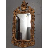 Mid 18th century giltwood wall mirror with shaped plate and heraldic cresting