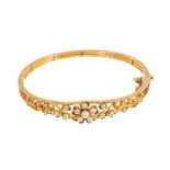Late Victorian gold and seed pearl hinged bangle with flower head and cloverleaf openwork design