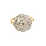 Diamond cluster ring with a flower head cluster of brilliant cut diamonds in grain and rub-over sett