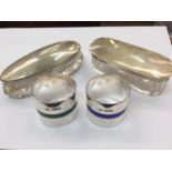 Two silver topped cut glass vanity jars and two silver and enamelled napkin rings