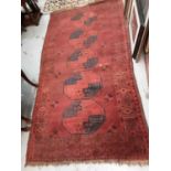 Eastern rug with geometric decoration on a red ground, together with another similar rug (2)