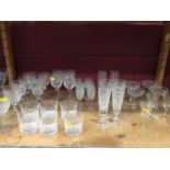 Collection of cut glassware decanters and drinking glasses, including Stuart etc
