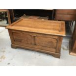 Oak coffer with panelled top and sides on bracket feet.