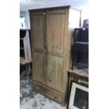 Early 19th century pine cupboard enclosed by two panelled doors with drawer below