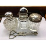 Three silver mounted glass vanity jars and pair Georgian silver sugar tongs