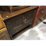 Old Charm style oak side cupboard, panelled doors with carved linen fold decoration, and draw below