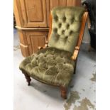 A late Victorian oak framed nursing chair with buttoned velvet upholstery on turned legs