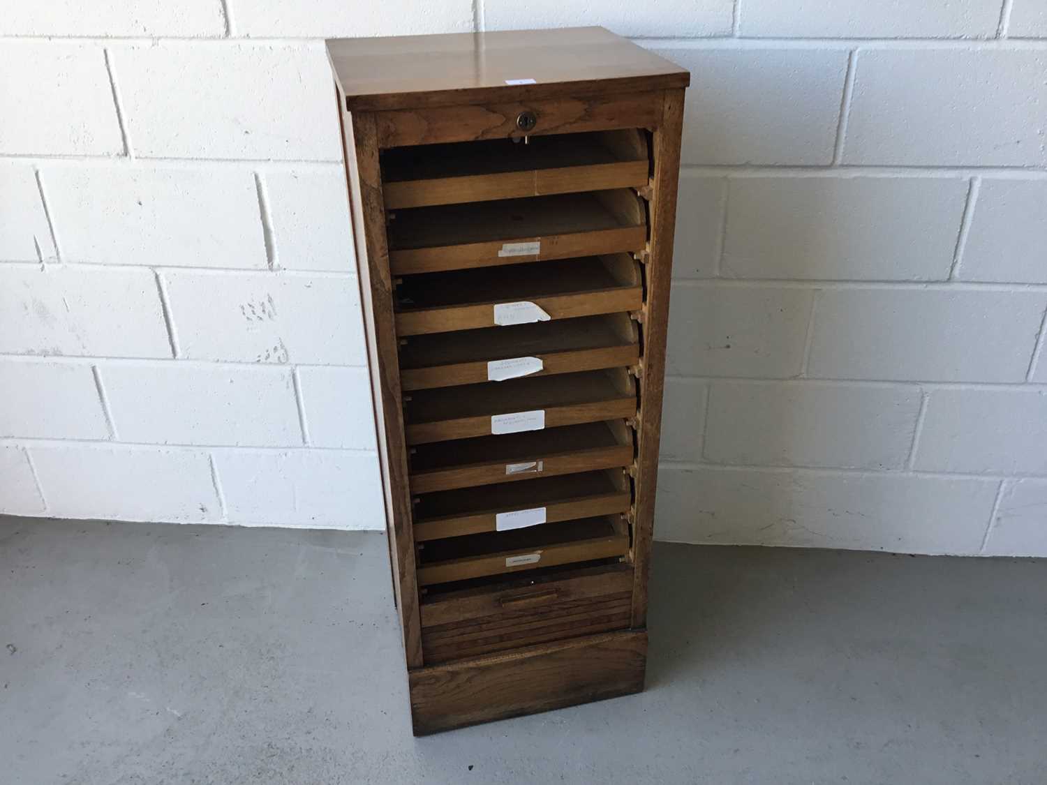 Edwardian oak stationary / filing cabinet with nine sliding shelves, enclosed by tambour shutter doo