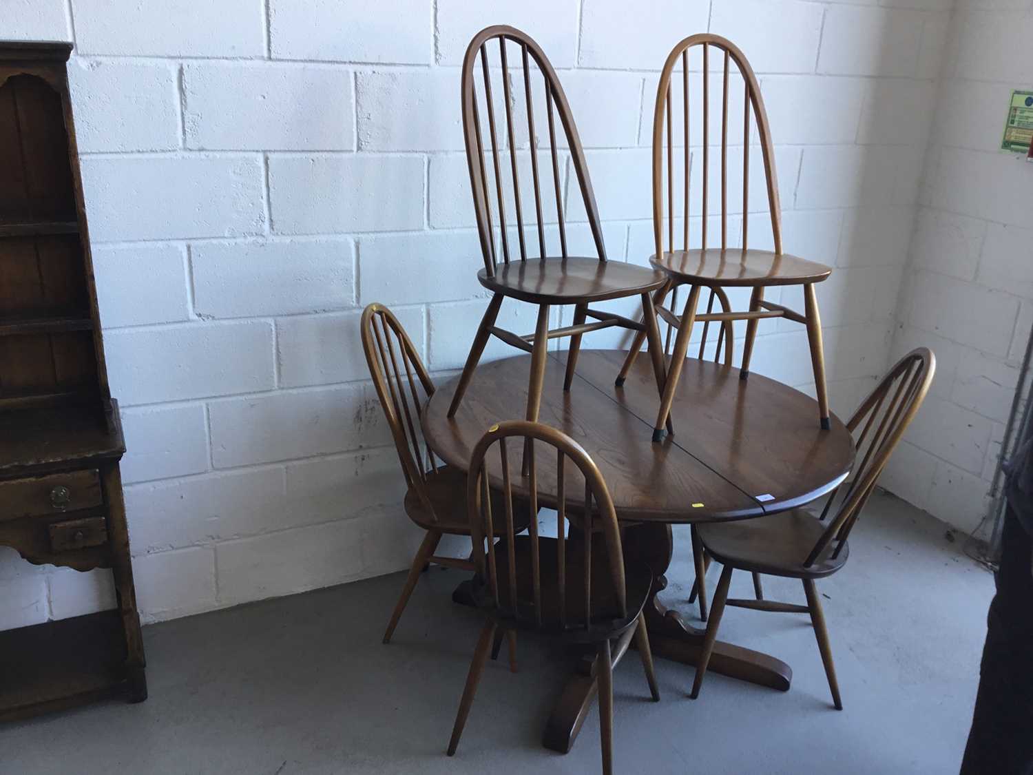 Ercol 'Golden Dawn' extending dining table of circular form, together with six Ercol stick back dini