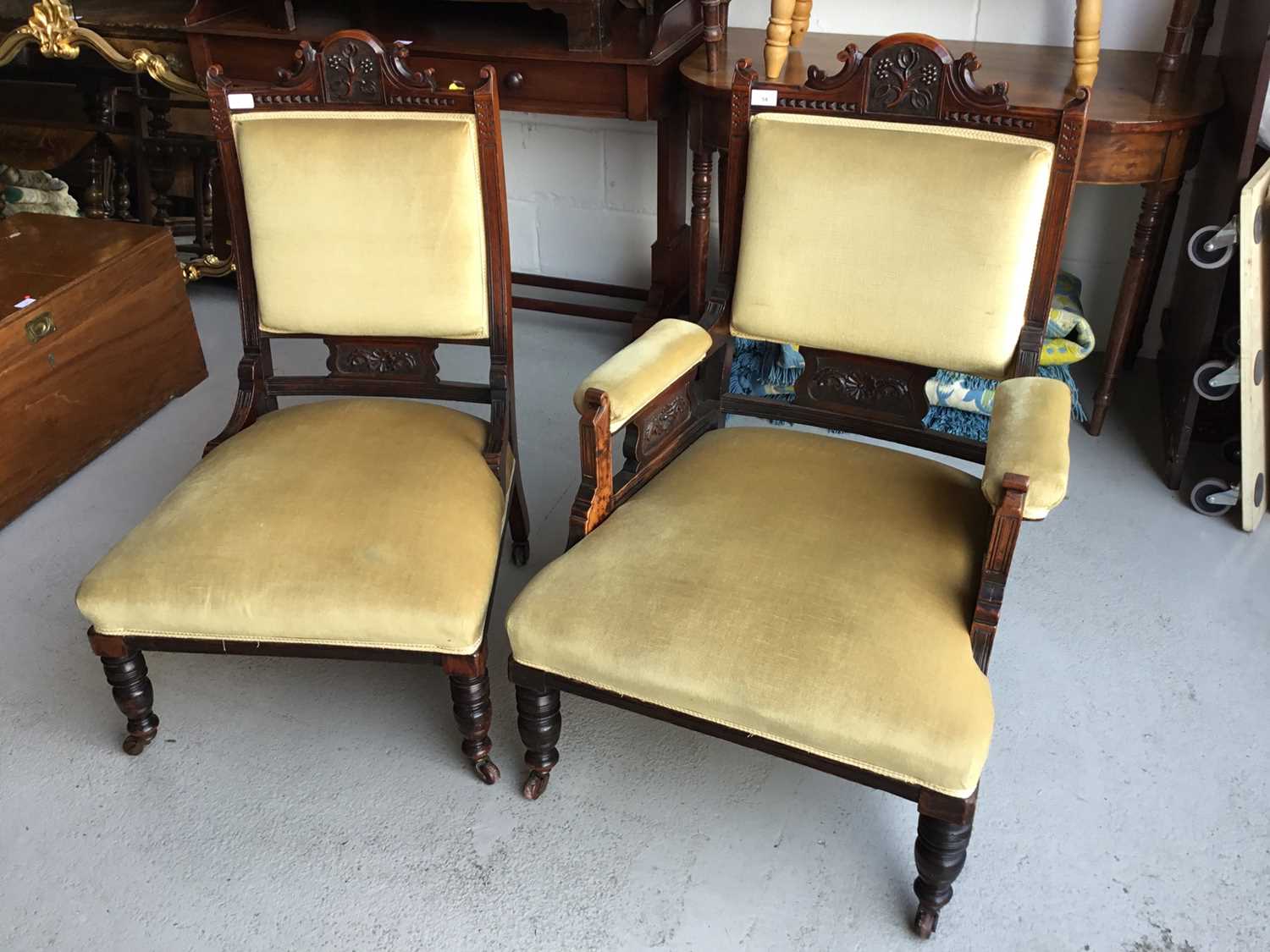 Edwardian carved wood armchair with green velvet upholstery and padded arms, on turned legs together