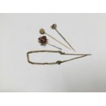 Group of four gold stick pins to include a novelty 9ct gold and enamel flying ladybird stickpin, and