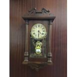 Oak hanging wall clock enclosed by glass frame with pendulum