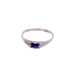 Art Deco sapphire and diamond ring with a rectangular step cut blue sapphire flanked by pavé set sin