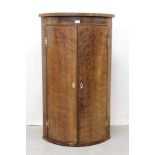 George III plum pudding mahogany bowfront hanging corner cabinet with brass H-shaped hinges enclosin