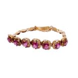 Gold and garnet bracelet with seven graduated mixed cut garnets in pierced gold setting