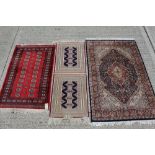 Pakistani rug with repeating medallion design on red ground, 155cm x 97cm, together with two other r