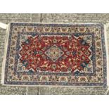Persian style part silk rug, with claret red ground and arabesque ornament.120 x 73cm