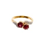 18ct gold two ruby cross over stone ring decorated with chip diamonds on flank
