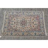 Good quality Persian silk rug with central medallion and trailing foliage on cream ground with