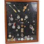 Group of silver and plated fobs together with medals and other items mounted in a glazed frame