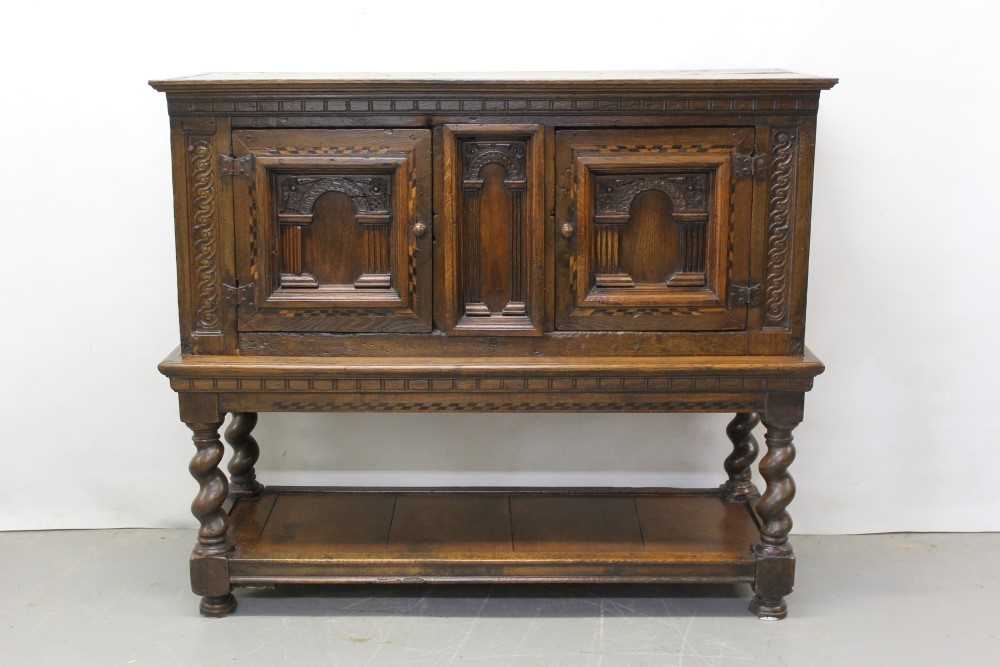 17th century and later oak cupboard on stand with central arched panel flanked by two arched panelle
