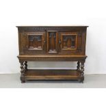 17th century and later oak cupboard on stand with central arched panel flanked by two arched panelle